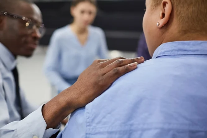 A man places his hand on the shoulder